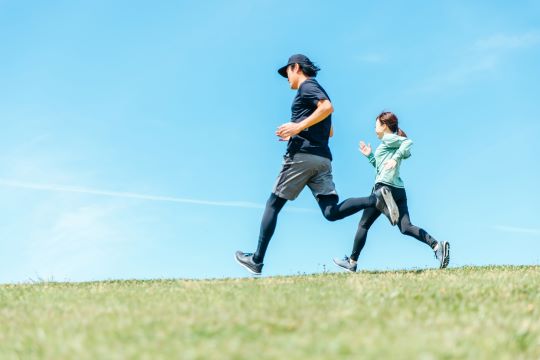 青空の下をランニングする男女