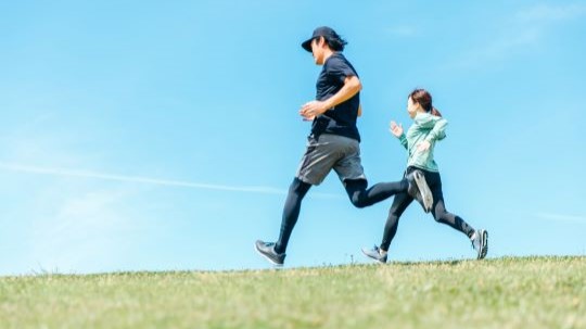 青空の下をランニングする男女