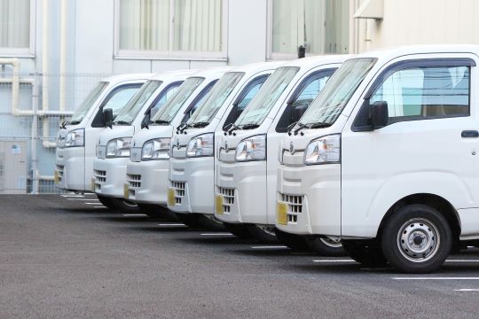 整列した軽トラックの配送車